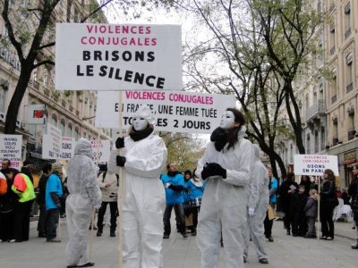 Photo avec des femmes portants des pancartes sur les violences conjugales