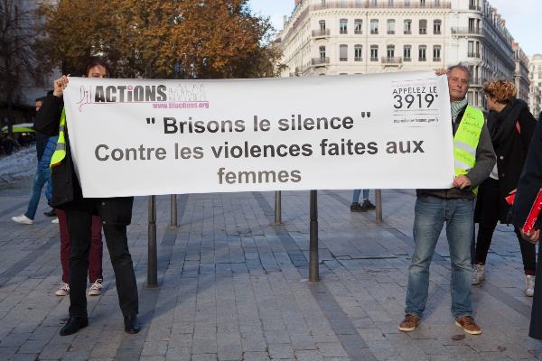 Deux membres de Filactions tiennent la banderole « Brisons le silence – Contre les violences faites aux femmes » dans une rue de Lyon