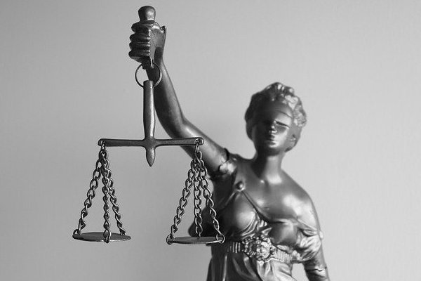Statue de la justice aux yeux bandés tenant une balance, en noir et blanc