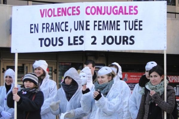 Militantes en blanc sous la banderole « Violences conjugales : en France, une femme tuée tous les 2 jours »